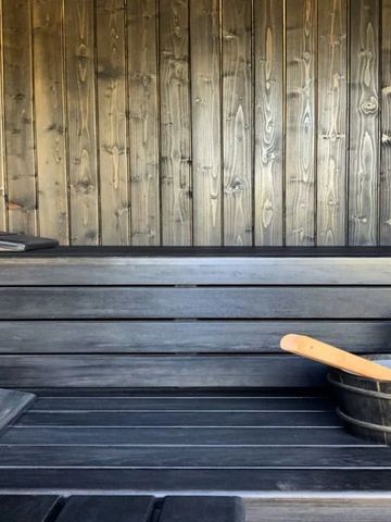 Gemütliche Sauna mit Holzwänden und Wasserkübel