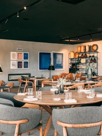 Elegantes Restaurantinterieur mit modernen Möbeln und Kunstwerken an der Wand