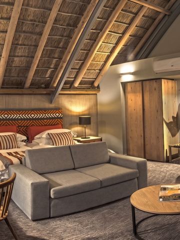 Gemütliches Schlafzimmer mit stilvoller Einrichtung und Holzdach.