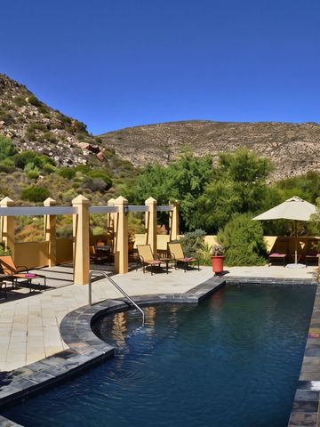 Privater Pool mit Liegestühlen im Grünen und Blick auf die Hügel.