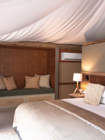 Luxuriöses Schlafzimmer mit gemütlichen Sitzgelegenheiten und Naturlampe.