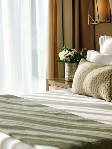 Elegantes Bett mit dekorativen Kissen in einem stilvollen Raum