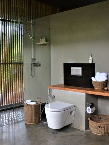 Modernes Badezimmer mit Glaswänden und Naturblick