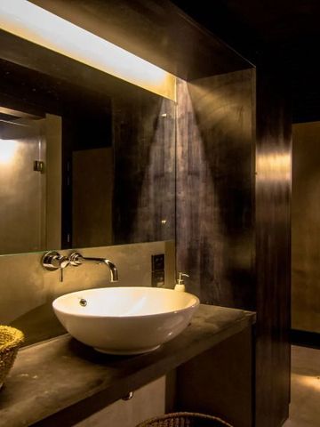 Elegantes Badezimmer mit modernem Waschbecken und stilvoller Beleuchtung.