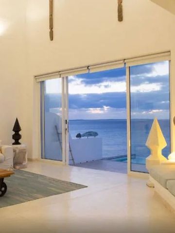 Wohnzimmer mit großem Fenster, Meerblick und gemütlicher Einrichtung.