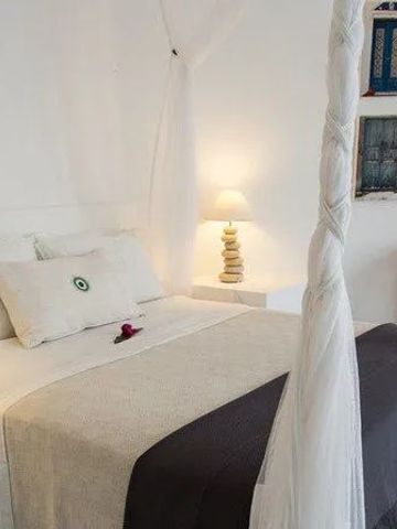 Helles Schlafzimmer mit Baldachinbett und stilvollen Dekorationselementen.