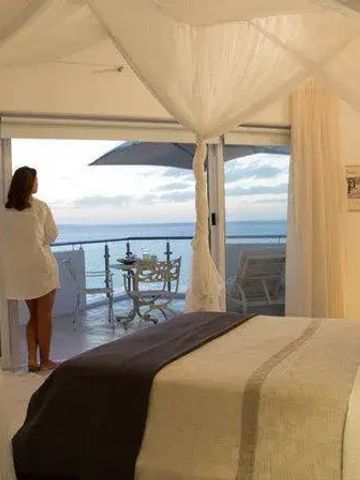 Schlafzimmer mit Blick auf den Ozean, Himmelbett und Balkon.