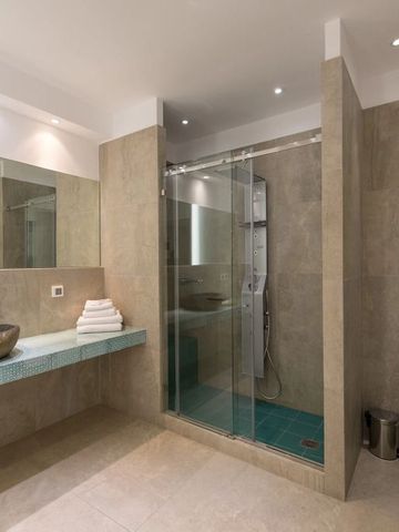 Geräumiges Badezimmer mit Glasdusche und Marmorwaschbecken