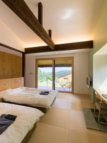 Zimmer mit Holzbalken und Ausblick auf die Naturlandschaft