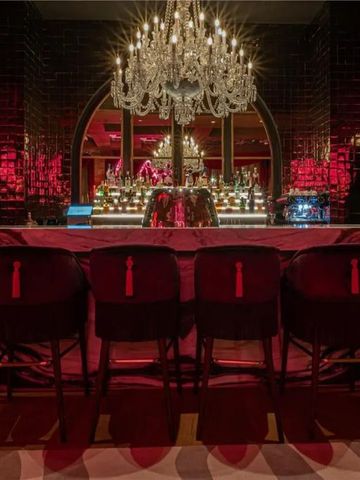 Luxuriöse Hotelbar mit glitzerndem Kronleuchter und stilvollen Hockern