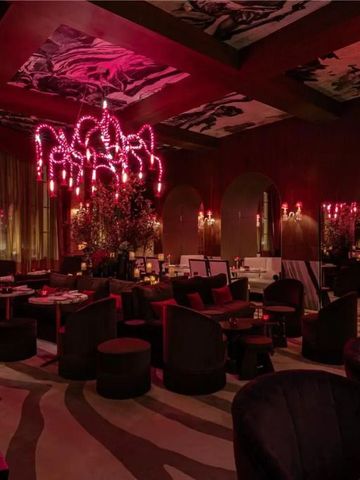 Dunkles, elegantes Restaurant mit auffälligem Kronleuchter und edler Einrichtung