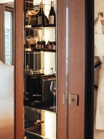 Gut ausgestattete Minibar mit Spiegelrückwand in einem Hotelzimmer