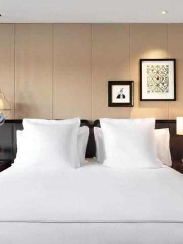 Elegantes Hotelzimmer mit großem Bett und moderner Kunst an der Wand
