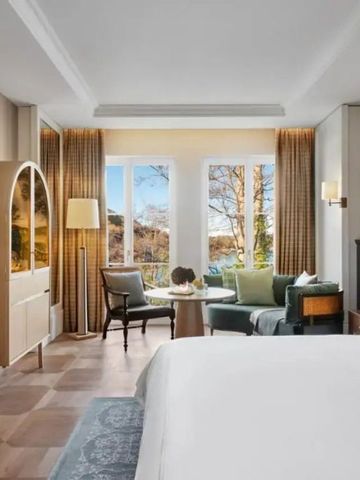 Helles Hotelzimmer mit Sitzbereich und Blick auf die Natur