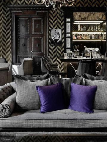 Luxuriöse Lounge mit grauem Sofa und violetten Kissen im Hotel