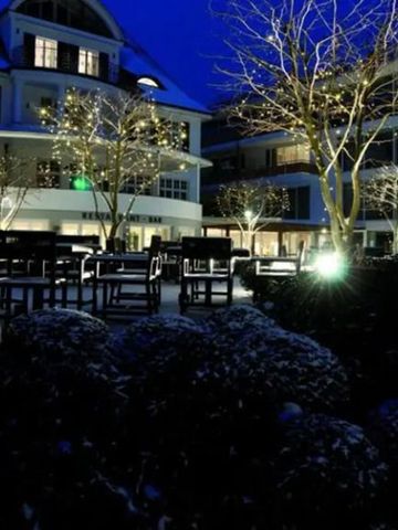 Hotelaußenansicht bei Nacht mit beleuchtetem Garten