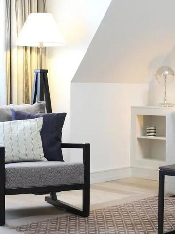 Moderner Wohnbereich mit Sessel und Sofaecke