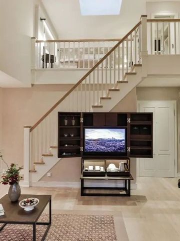 Helles Wohnzimmer einer Maisonette-Suite mit eleganter Treppe und gemütlicher Einrichtung
