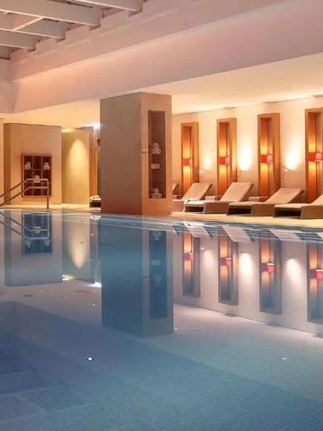 Schwimmbad im Innenbereich mit Liegestühlen und stimmungsvoller Beleuchtung