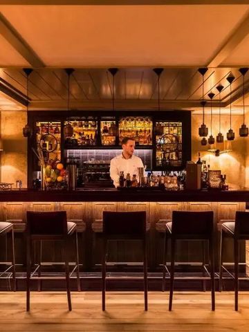 Elegante Hotelbar mit zeitgemäßem Design und beleuchteten Regalen