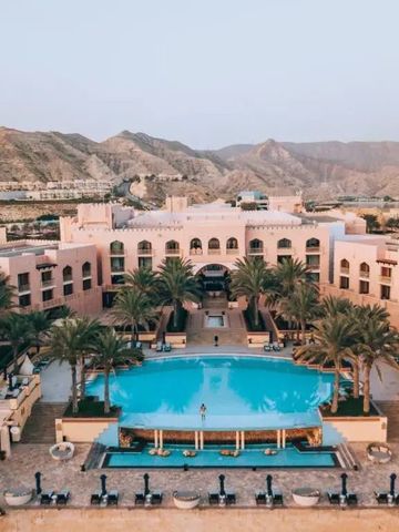 Blick auf den großen Pool im Zentrum des Shangri-La Al Husn, umgeben von Palmen