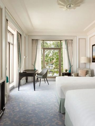 Helles Doppelzimmer mit großen Fenstern und elegantem Dekor