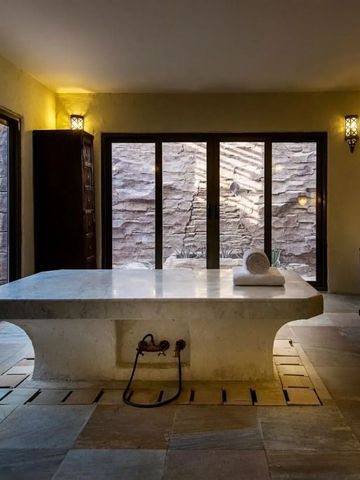 Geräumiges Spa-Zimmer mit Blick auf natürliche Felsen und Kategoriebeleuchtung.