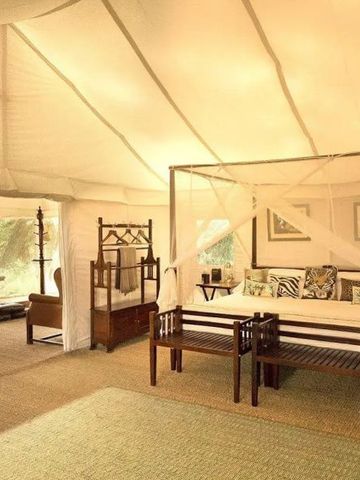 Elegant eingerichtetes Inneres eines Safari-Zeltes mit Himmelbett