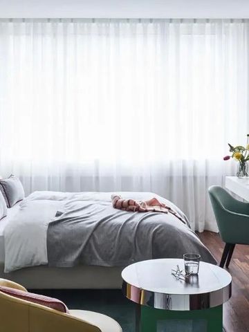 Helles, elegantes Hotelzimmer mit modernem Interieur und großem Fenster