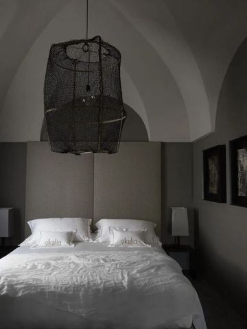 Luxuriöses Schlafzimmer in gedeckten Farben mit einzigartiger Hängelampe