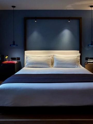 Stilvolles Doppelbettzimmer mit elegantem Holzdesign und stimmungsvoller Beleuchtung