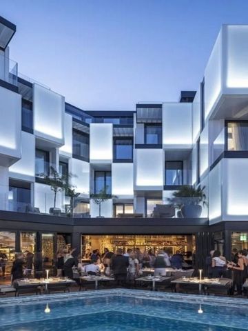 Modernes Hotelgebäude mit stilvoller Beleuchtung am Abend und lebhafter Außenlounge.