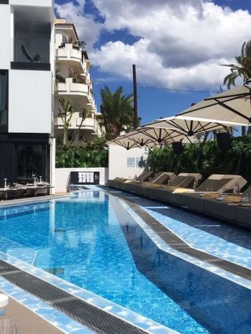 Luxuriöser Außenpool mit Liegen und Sonnenschirmen neben einem modernen Hotelgebäude.