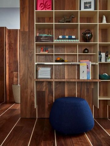 Holzvertäfeltes Zimmer mit Bücherregal und eleganter Sitzgelegenheit.