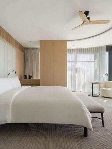 Helles Zimmer in Dubai-Hotel mit großen Fenstern und luxuriösem Bett.