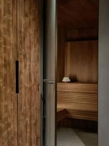 Exklusive Sauna mit Holzwänden und moderner Tür