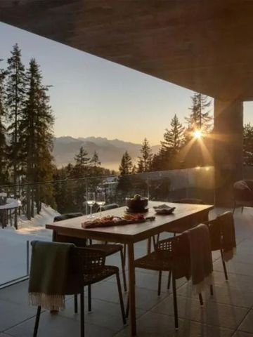 Terrasse mit Tischen und spektakulärer Aussicht auf die Berge bei Sonnenuntergang