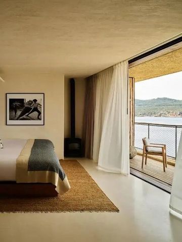Modernes Schlafzimmer mit großer Glasfront und herrlichem Ausblick aufs Meer