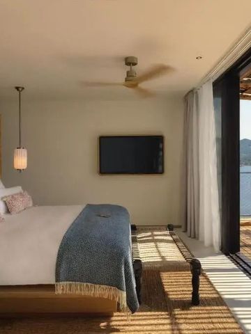 Gemütliches Schlafzimmer mit offener Veranda und Blick auf eine Bucht
