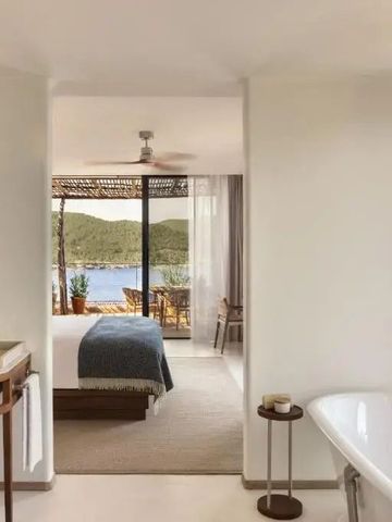 Freistehende Badewanne mit Blick auf das Meer und Zugang zu einem privaten Zimmer