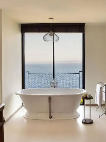 Luxuriöses Badezimmer mit freistehender Badewanne und Meerblick