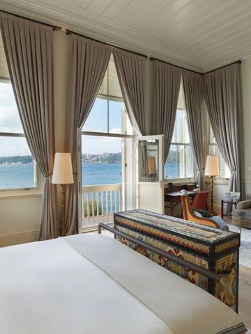 Luxuriöses Zimmer mit großem Bett und Blick auf das Meer durch große Fenster