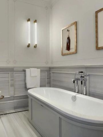 Geräumiges Badezimmer mit freistehender Badewanne und Kunstwerken
