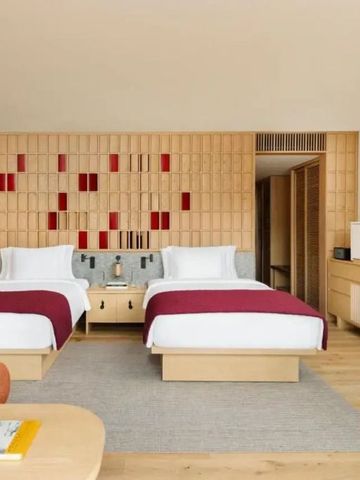 Hotelzimmer mit zwei Betten und minimalistischer Einrichtung