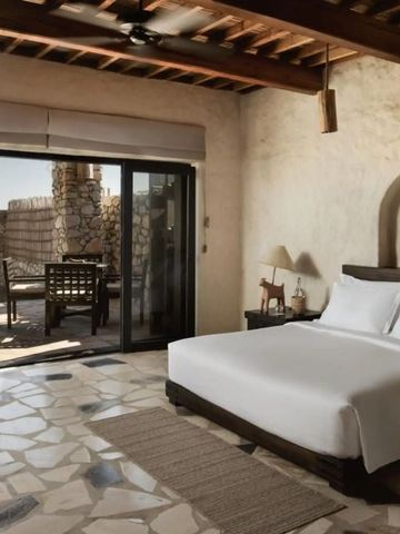 Schlafzimmer mit Natursteinboden und privatem Patio