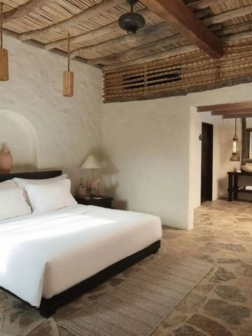 Geräumiges Schlafzimmer mit Steinboden und elegantem Badzugang