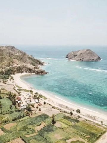 Küstenausblick mit Strand und Insel im türkisfarbenen Meer