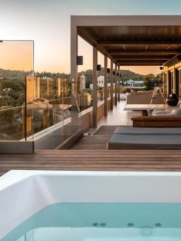 Dachterrasse mit Liegen und Whirlpool bei Sonnenuntergang