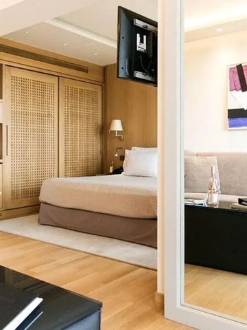 Elegantes minimalistisches Hotelzimmer mit Kunstwerk an der Wand und flauschigem Bett.