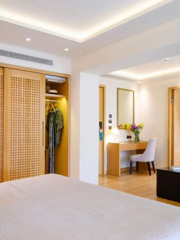 Helles und freundliches Hotelzimmer mit Schrank und Schreibtisch in warmen Holztönen.